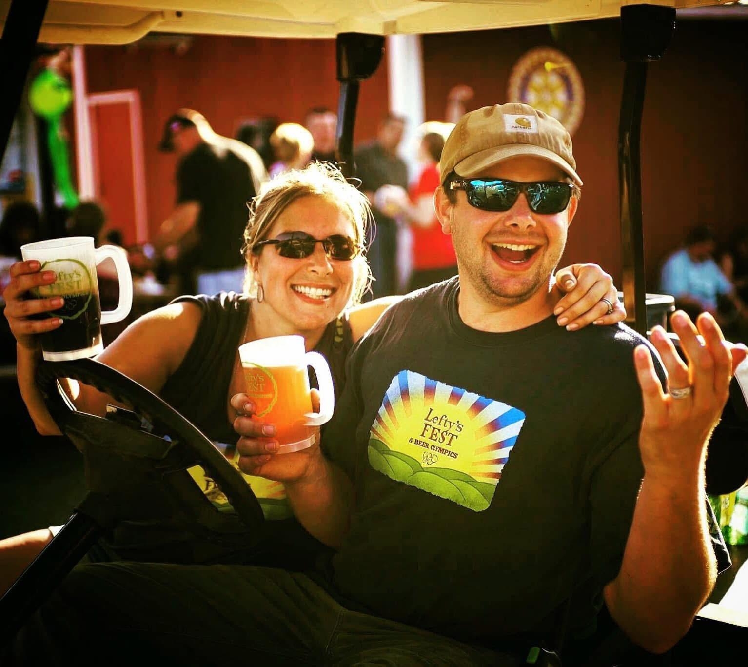 A Man and a Woman holding beer smiling at the camera